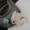 Mushie Babete Silicone Dinossauros +6M | Ajustável e Fácil de Limpar
